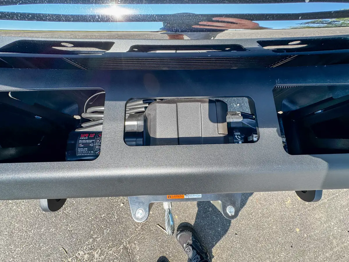 Front grille close-up with central emblem and guard bar shadowing.